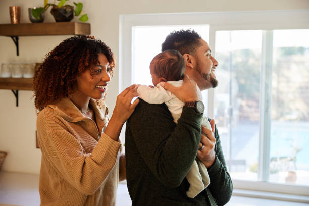 istock Parents smiling and playing with their baby in their kitchen 1369111280