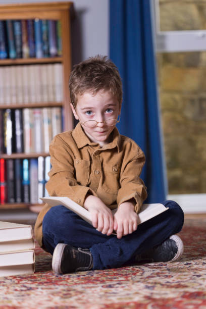 7-year-old boy sitting on the floor reading a book.