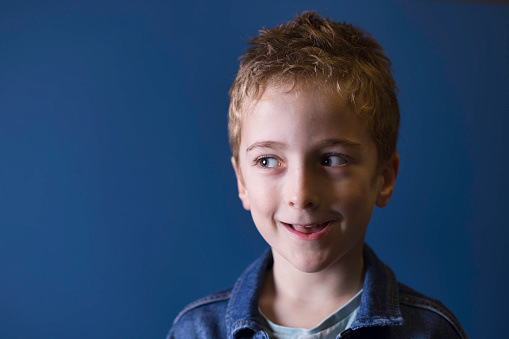 Portrait of a cheerful young boy wearing a denim jacket.
