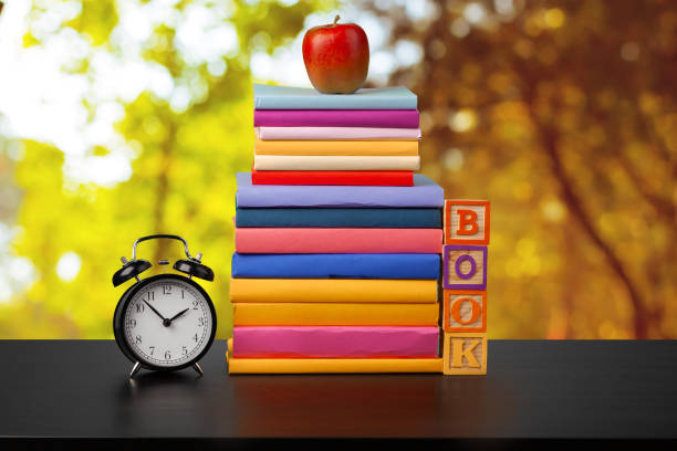 istock Stack of books on wooden table against blurred background 1369114602