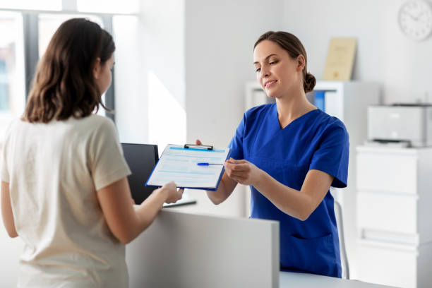 médecin avec presse-papiers et patient à l’hôpital - receptionist photos et images de collection