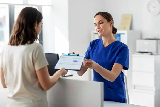 Photo of doctor with clipboard and patient at hospital