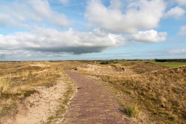 istock A pathway through the dunes to a small town in the Netherlands on a cloudy day 1369118410