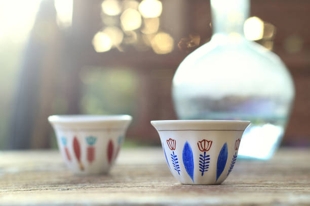Two Lebanese traditional coffee cups along with a glass water jug, ebrik, for a taditional morning chat.