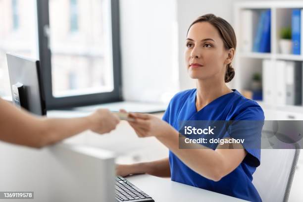 Doctor And Patient With Credit Card At Hospital Stock Photo - Download Image Now - Paying, Receptionist, Healthcare And Medicine