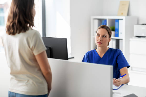 istock doctor with computer and patient at hospital 1369120159
