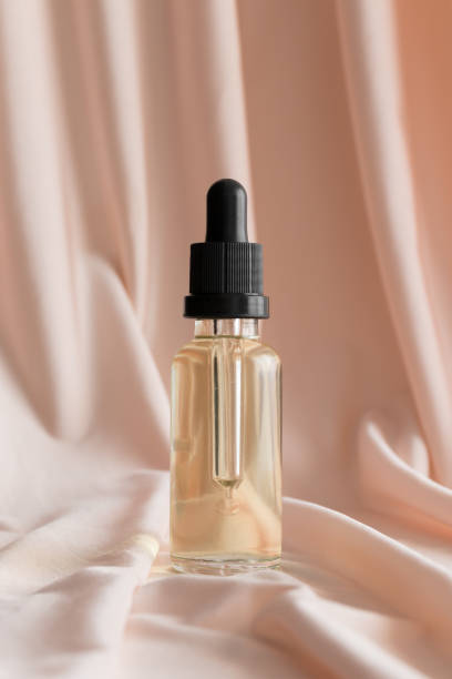 istock Dropper bottle mockup on the soft pink textile. 1369120265