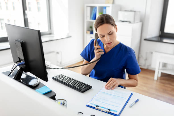 doctor with computer calling on phone at hospital stock photo