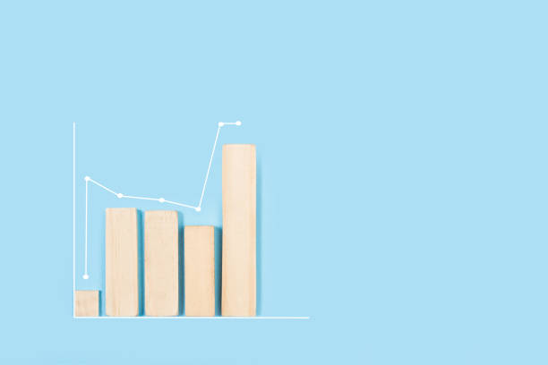 istock Wooden bars in a financial graphic shape on a light blue background 1369120973