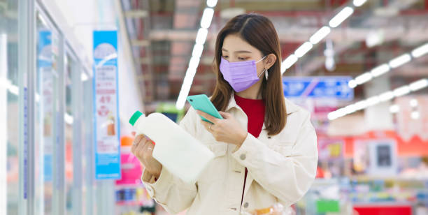 woman scanning milk asian young woman is shopping for milk and scanning barcode with smart phone at supermarket scanning activity photos stock pictures, royalty-free photos & images