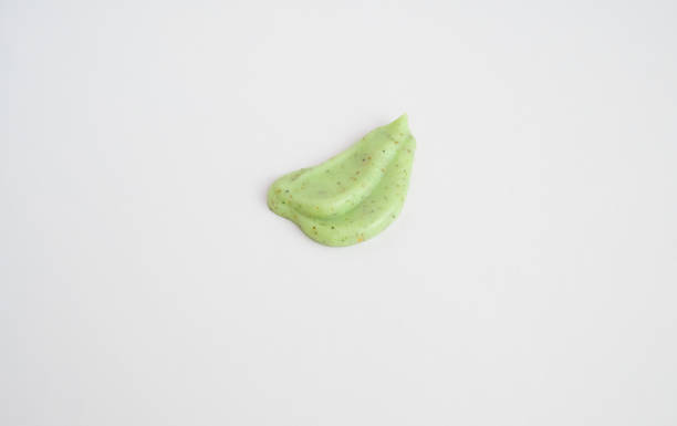 istock A sample of a natural green scrub on a white background. Peeling cream with microcapsules. Smear of apple or coffee scrub. 1369122516