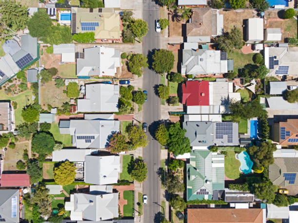 Looking down on suburban street in Adelaide's inner northern suburbs Aerial view of houses and properties in a suburban street in Adelaide's inner northern suburbs: tree-lined with different roof types, varying neatness and with some solar panels evident. Also swimming pools, trampolines, lawns, gardens, driveways. tree lined driveway stock pictures, royalty-free photos & images
