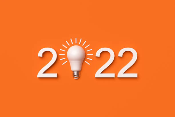 istock 2022 and white light bulb on orange background. 1369126966