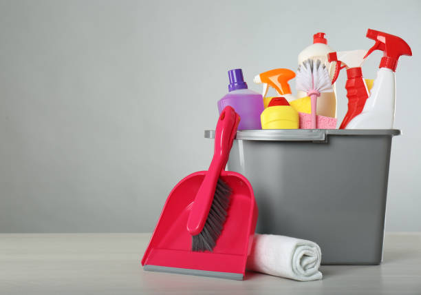 istock Bucket with different cleaning products and supplies on light table. Space for text 1369127745
