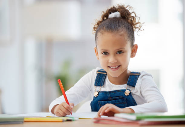 自宅で宿題をしている小さな女の子のショット - 6歳から7歳 ストックフォトと画像