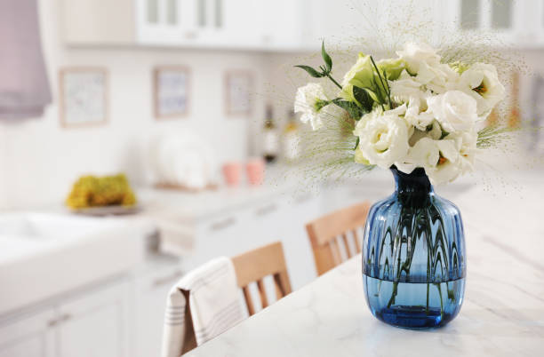 istock Bouquet of beautiful eustoma flowers on white table in kitchen. Interior design 1369128031