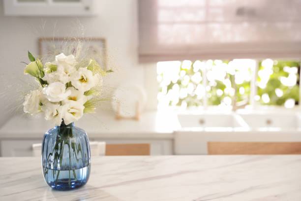 istock Bouquet of beautiful eustoma flowers on white table in kitchen. Interior design 1369128043