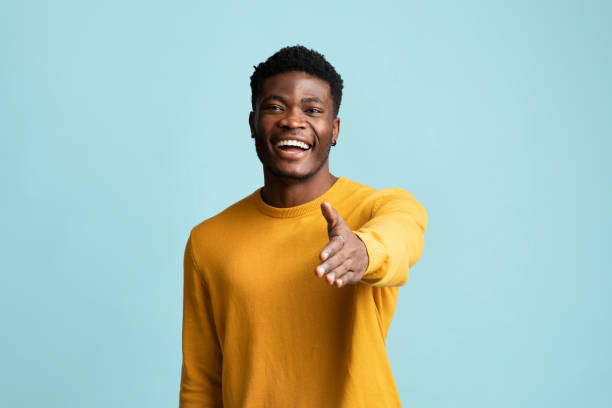 istock Friendly black guy outstretching hand towards camera 1369128853