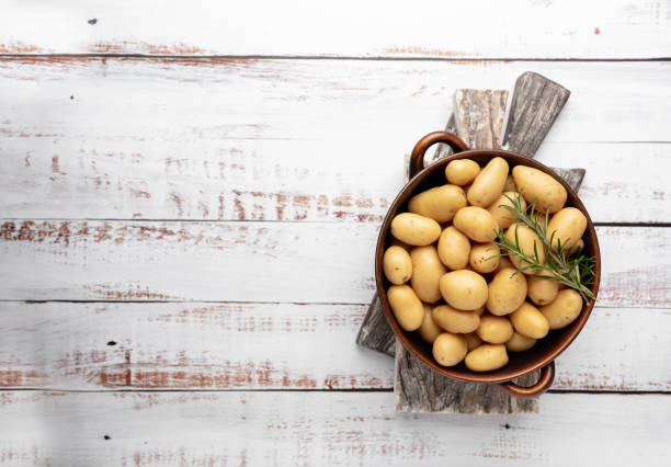 istock Raw small potatoes in a cast iron skillet on a beton background. 1369129105