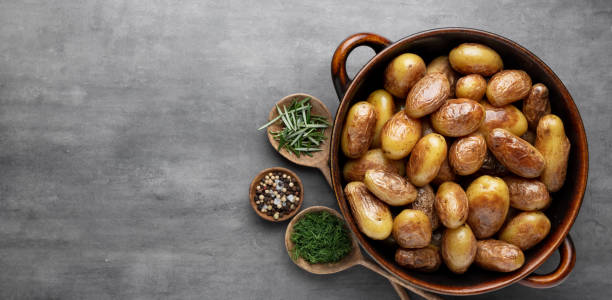 istock Pan filled with roasted potatoes shot on rustic wooden table. 1369129106