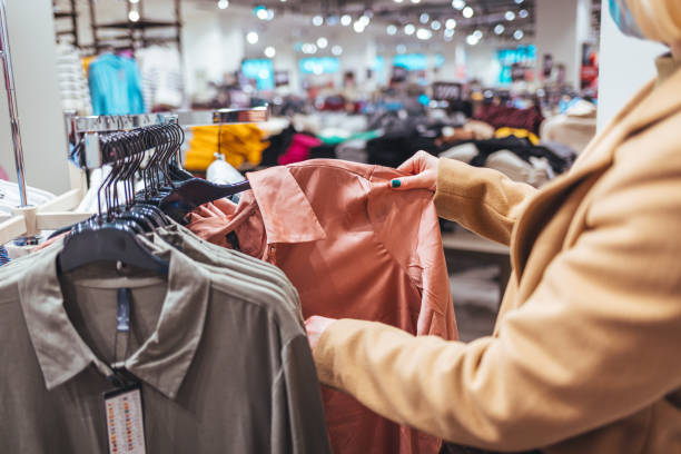 istock Female customer chooses clothes in a store 1369129279