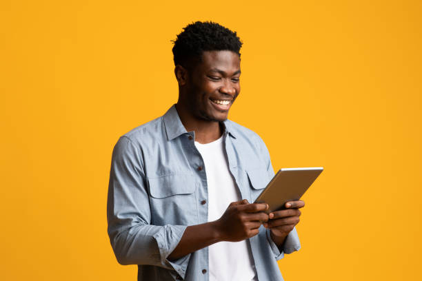 istock Happy african american guy holding digital tablet and smiling 1369129481