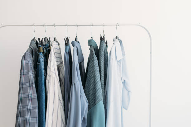 Rack with capsule clothes in blue colors closeup stock photo