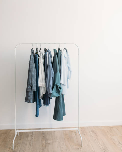 Rack with capsule clothes in blue colors stock photo