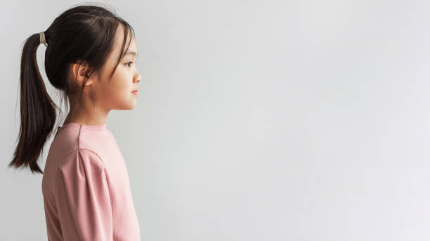 profile portrait of serious asian girl looking aside, gray background - japanese girl imagens e fotografias de stock