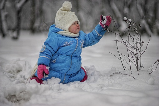 Royalty free stock photo of child playing in the snow.Shot in RAW and post processed in Prophoto RGB. This file has a signed model release.