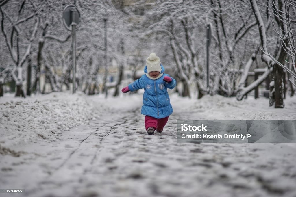 Happy snow baby girl First snow for Anna Baby Clothing Stock Photo