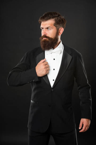 istock bearded bridegroom in tuxedo on black background, bow tie 1369137048