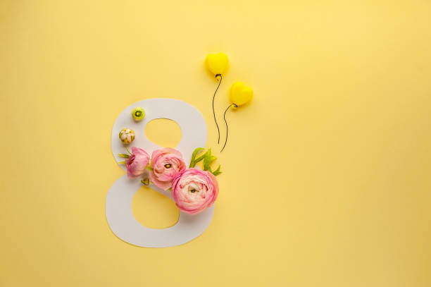 istock Pink ranunculus decorates the number eight on yellow background. 1369138624