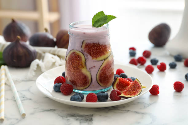 istock Delicious fig smoothie in glass jar on white marble table 1369138658