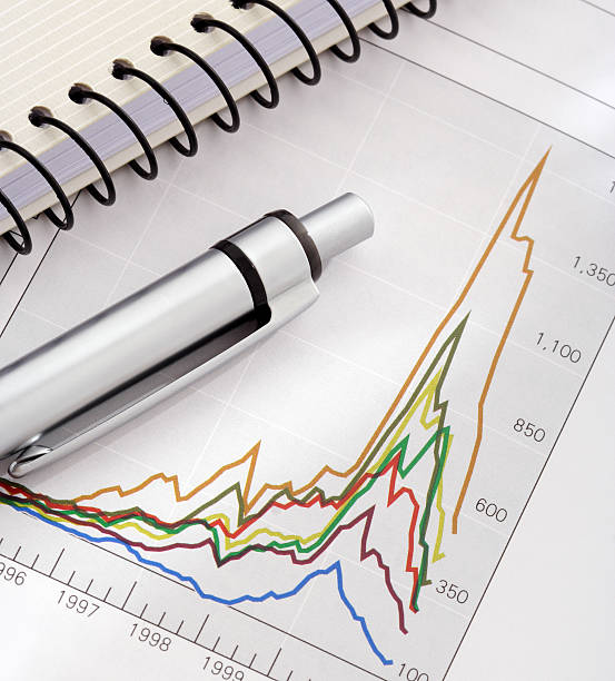 ペンとノートパソコンにグラフ - comparison graph curve finance ストックフォトと画像