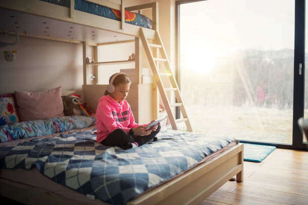 istock Young girl using digital tablet at home. 1369141000