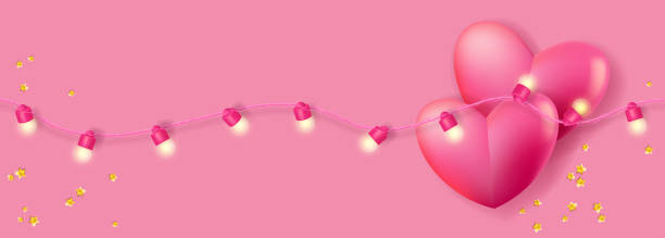 istock Two pink hearts in a glowing garland of lights 1369141262