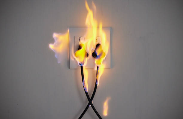 istock Cropped shot of two plugs in a wall socket catching fire 1369141298