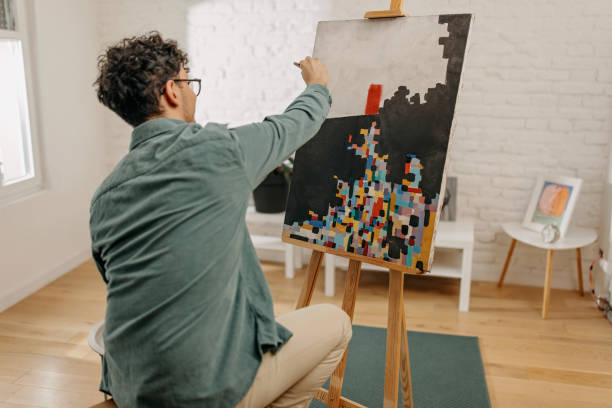 istock Young man painting and relaxing at home 1369141376