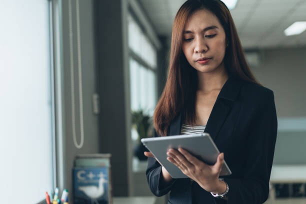 istock Asian female employee working on digital tablet in the office. checking and preparing for work 1369141547