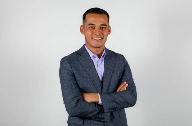 Young smiling man in a classic suit isolated on white background crossed hands