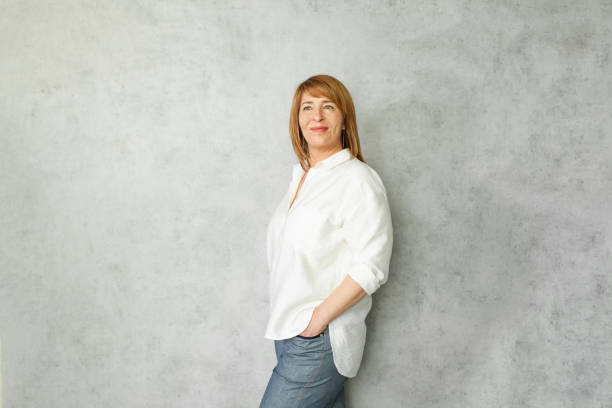 istock Cheerful middle aged woman smiling on gray background 1369144827