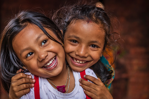 Nepali little girls posing in an ancient temple in Bhaktapur. Bhaktapur is an ancient town in the Kathmandu Valley and is listed as a World Heritage Site by UNESCO for its rich culture, temples, and wood, metal and stone artwork.