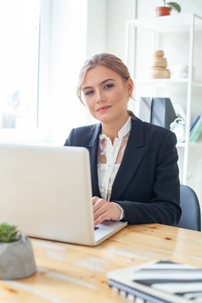 istock Happy woman using laptop computer at office 1369146670
