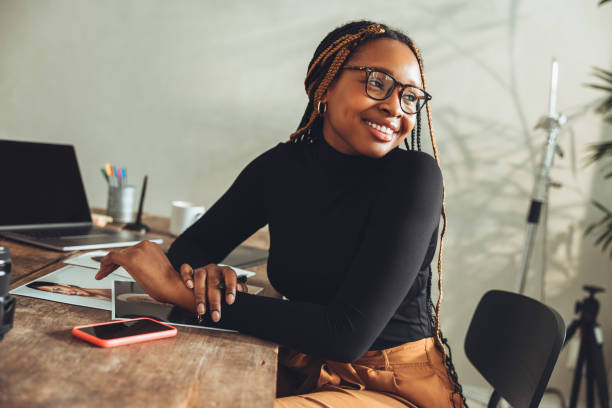 istock Imaginative young woman smiling in her home office 1369148251