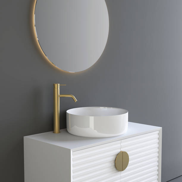 Close up of sink with oval mirror standing in on grey wall stock photo