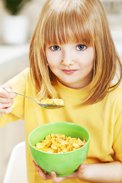 istock Little girl eating cornflakes for breakfast 1369149993