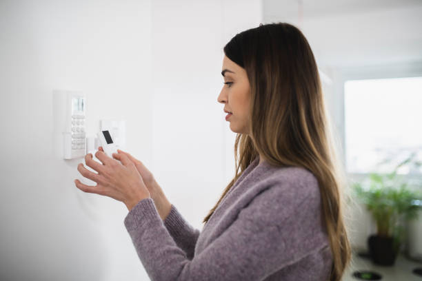 istock Beautiful woman setting up smart system for home appliance 1369150053
