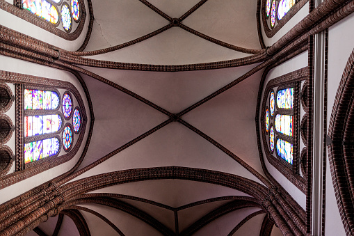 ceiling of a Catholic church with stained glass windows in Poland.