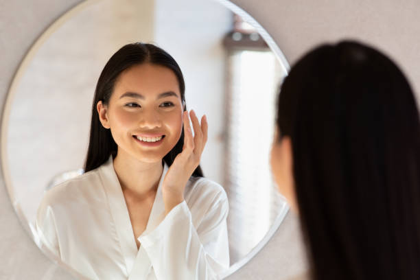istock Happy beautiful korean lady using moisturising face cream 1369151911